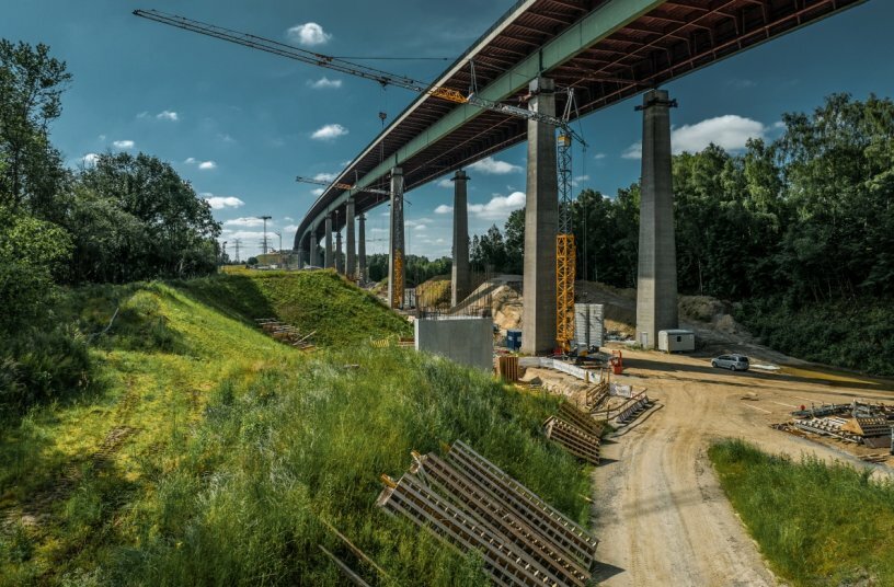 Some of the K cranes on site slew under the bridge and are therefore set up with their towers retracted.<br>IMAGE SOURCE: Liebherr-Werk Biberach GmbH