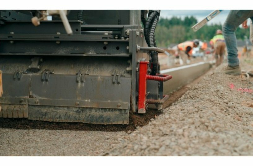 Positioned directly in front of the slipform mould, the Trimmer levels off the previously consolidated substrate to ensure consistently even paving results.<br>IMAGE SOURCE: WIRTGEN GROUP