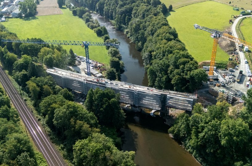 Perfectly planned for efficient lifting operations. BKL positioned the two heavy-duty cranes on opposite banks of the river, with radii of 70 and 80 metres. The cranes thus covered the entire length of the bridge – almost 170 metres – without the need for time-consuming crane reassembling.<br>IMAGE SOURCE: Albert Weil AG