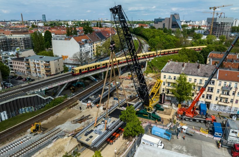 Die zweite Eisenbahnbrücke wird bei laufendem S Bahnbetrieb am Nachbargleis montiert.<br>BILDQUELLE: Liebherr-Werk Ehingen GmbH