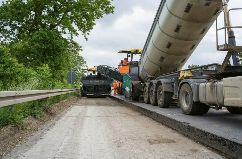 A Vögele MT 3000-3i PowerFeeder transferring BSM cold mix to the SUPER 1900-3i paver.<br>IMAGE SOURCE: WIRTGEN GROUP