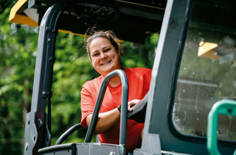 Fertigerfahrerin Tatjana Drexler profitiert beim Einbau von der optimalen Übersicht, der feinfühligen Lenkung per SmartWheel und der exakten Bohlenbreitenverstellung des Vögele Straßenfertigers.<br>BILDQUELLE: WIRTGEN GROUP
