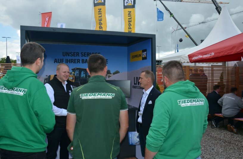 Nils Oltmanns (Zweiter von links), Servicetechniker der Zeppelin Niederlassung Bremen, erläutert interessierten Besuchern die Vorteile des Zeppelin Remote Service.<br>BILDQUELLE: Zeppelin Rental GmbH