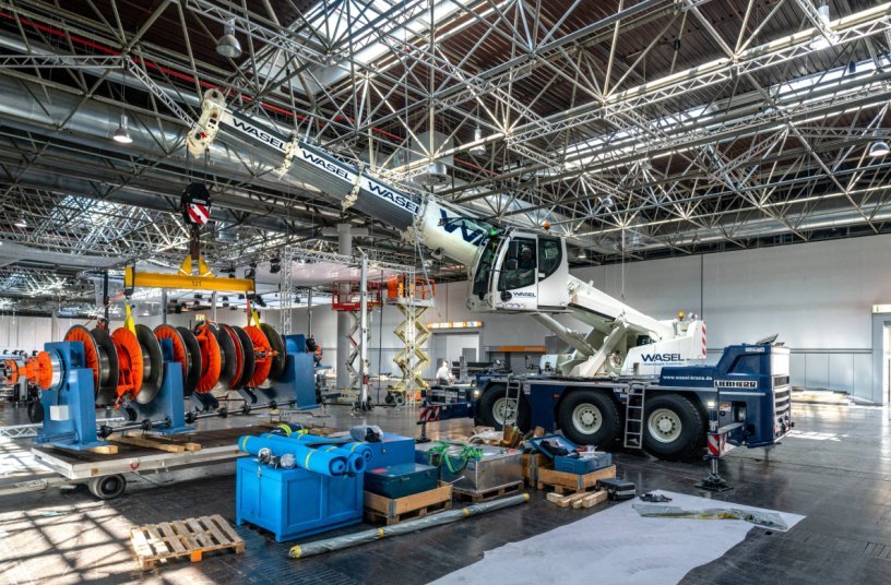 XXL exhibition stand construction: In some cases, large exhibits had to be moved precisely by the Liebherr LTC 1050-3.1 via the telescopic extension. Due to the low ceiling height, positioning the load via the boom inclination was almost impossible.<br>IMAGE SOURCE: Liebherr-Werk Ehingen GmbH