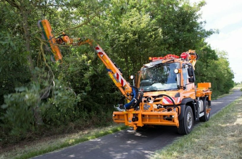 Unimog implement carrier with front mower, hedge trimmer, and spreader<br>IMAGE SOURCE: Daimler Truck AG