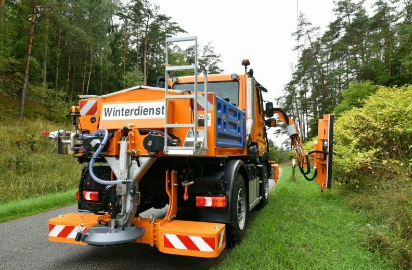 Unimog implement carrier with front mower, hedge trimmer, and spreader<br>IMAGE SOURCE: Daimler Truck AG