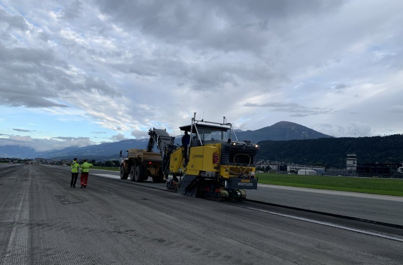 Bei der Generalsanierung der Piste am Flughafen Innsbruck wurden zuerst 57.000 Tonnen Asphalt abgetragen und später wurde dieselbe Menge neuer Asphalt wieder aufgetragen. <br> Bildquelle: KUHN Baumaschinen GmbH