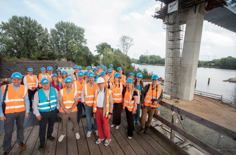 Participants of the trade press tour view the Rader High Bridge construction site across the Kiel Canal. The replacement structure is one of Germany’s and Europe’s most important infrastructure projects.<br>IMAGE SOURCE: Holstenhallen Neumünster GmbH; SIXCONCEPT