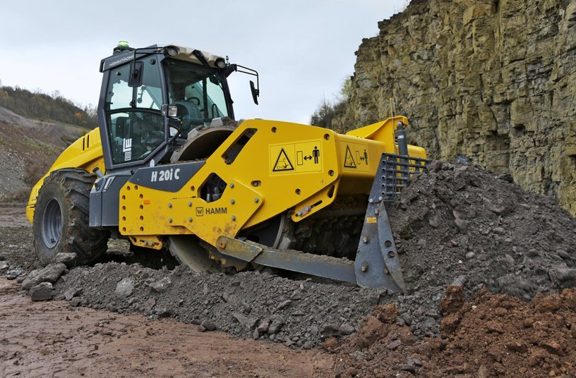 Two 20 t compactors with padfoot drum, dozer blade and reinforced hydrostatic drive (C models) are in operation at the Wilhelmsglück quarry. With a dozer blade and 30% higher torque, they effortlessly move the material, which is delivered in dumping heights of between 50 cm and 1 m. <br> Image source: WIRTGEN GROUP; Hamm