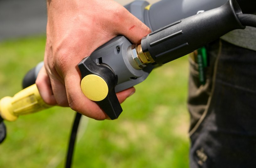 Über die Armatur am ergonomisch gestalteten Handgriff der Teleskoplanze lässt sich schnell und bequem der Zulauf des Wassers aus dem Hochdruckgerät regulieren und das iSolar-Bürsten-System schalten.<br>BILDQUELLE: Alfred Kärcher SE & Co. KG