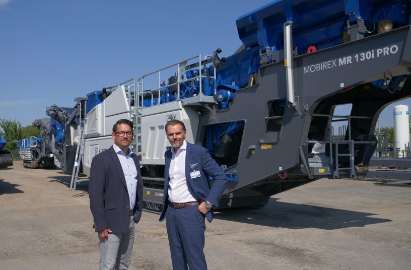 Hand-over of the MOBIREX MR 130i PRO in the Kleemann plant in Göppingen: Christoph Obalski, Sales Wirtgen Germany (left) with Dirk Frorath, managing director of the operating company AMIRO GmbH in the Oetelshofen quarry (right)<br>IMAGE SOURCE: WIRTGEN GROUP