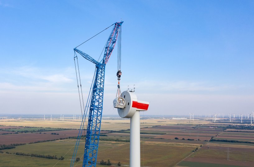 Well designed – the 15 metre lattice jib on the 168 metre boom makes for safe handling with the top components of the wind  turbine during the assembly process. Our photograph shows the installation of the hub. <br> Image source: Liebherr-Werk Ehingen GmbH