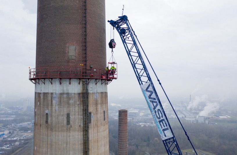 Gesichert mit Fallschutz-Ausrüstung steigen die Experten vom Sprengteam in 140 Meter Höhe auf ihr Arbeitsgerüst um. <br> Bildquelle: Liebherr-Werk Ehingen GmbH