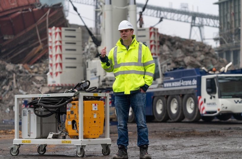 In case of emergency – Project Manager Maurizio Ising explains how the hydraulic unit works to enable the safety cage on the crane’s hook to be lowered at any time if the crane’s engine suffers a failure. <br> Image source: Liebherr-Werk Ehingen GmbH