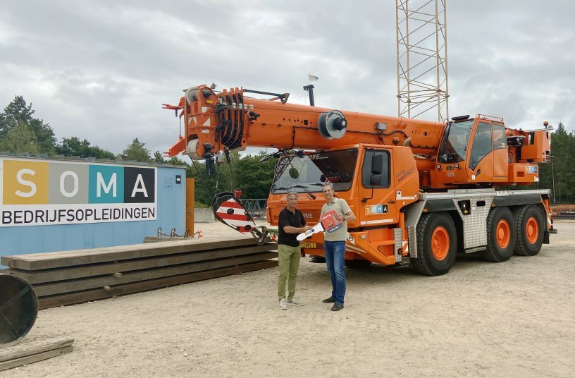 Erik Baas of Manitowoc (left) and Jeroen Boekelo of SOMA (right) celebrate the delivery of the Grove GMK3060-1.<br>IMAGE SOURCE: THE MANITOWOC COMPANY, INC.
