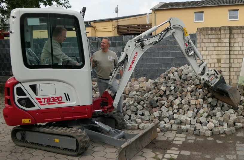 Der Takeuchi TB 320 mit dem Taklock-Schnellkupplungssystem macht den Wechsel hydraulische Anbaugeräte einfach. Gärtnermeister Sven Busse und Oliver Knabjohann v.l.<br>BILDQUELLE: Wilhelm Schäfer GmbH