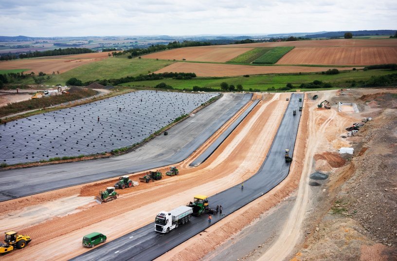 In the first phase, the earthworks on the 25,000-m2 site were carried out in parallel in several sections with the aid of Wirtgen tractor-towed stabilisers, Hamm soil compactors and John Deere motor graders. After this, Vögele pavers placed two layers of specially formulated landfill asphalt mix, which were then compacted by smooth drum soil compactors.<br>IMAGE SOURCE: WIRTGEN GROUP
