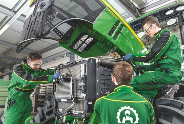 Apprentices working on a John Deere ag tractor