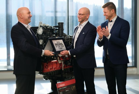 Powertrain International Editor-in-Chief Fabio Butturi (left) presents the Diesel Engine of the Year 2026 award to AGCO Power Vice President Juha Tervala. Next to them, AGCO Power Project Manager for Engineering Juha-Pekka Asikainen applauds. In the background: the CORE80 engine.