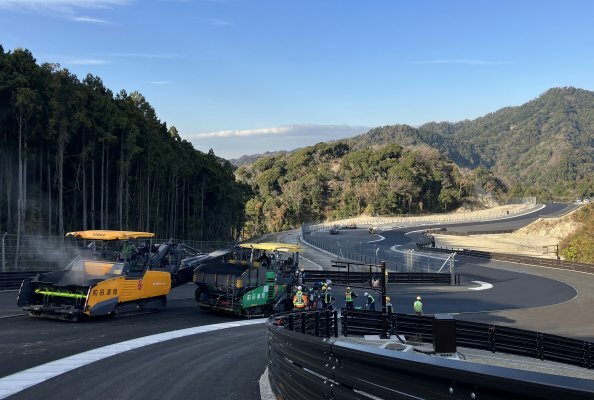Unique race track near Tokyo: three pavers and a material feeder from Vögele completed the four-layer paving operation in this undulating landscape.