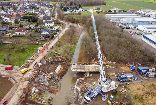 THW Bielefeld hoists a 46 tonne temporary bridge with the help of the LTM 1650-8.1 over the River Erft in the Euskirchen 
disaster zone. It will be a massive help to the people there and represents a major step forward in the reconstruction efforts.