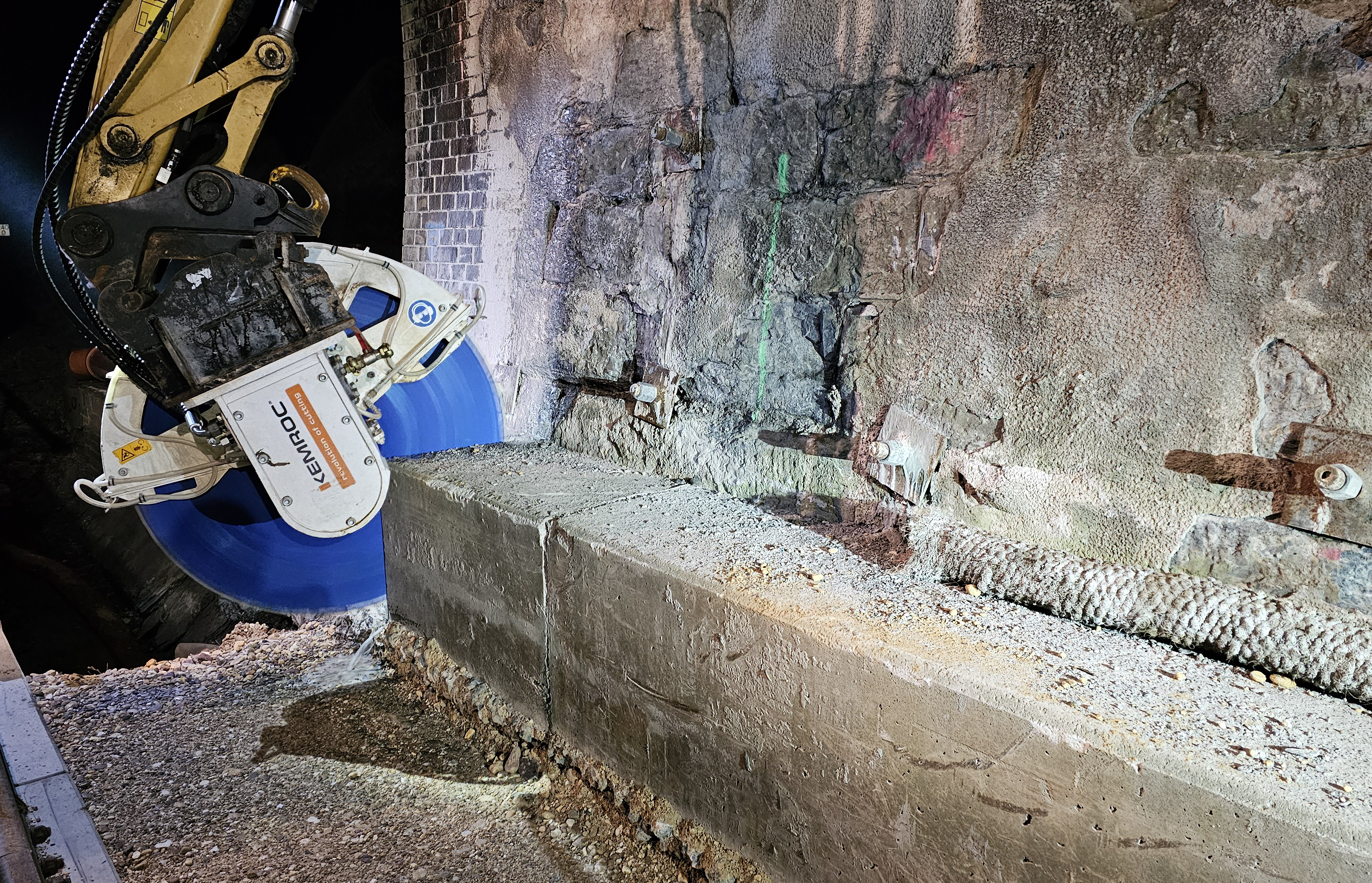 Cutting through the cable duct – with little dust thanks to water spraying. Then the cut section of concrete is lifted loose and loaded for transport.